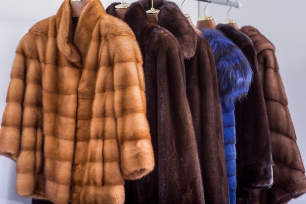 Mink coats of different colors in a shop on a hanger.