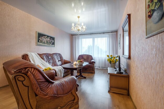 Minsk belarus august 2021 big leather sofa in interior the\
modern living room with tv and candles