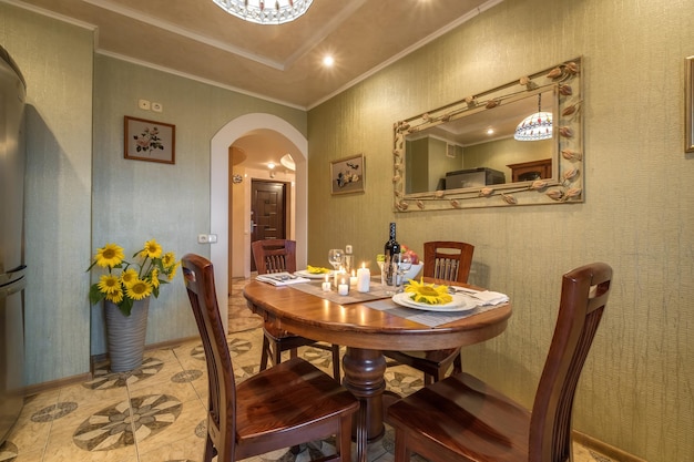 MINSK BELARUS AUGUST 2021 Interior of kitchen in studio apartments with a served table with wine fruit and candles