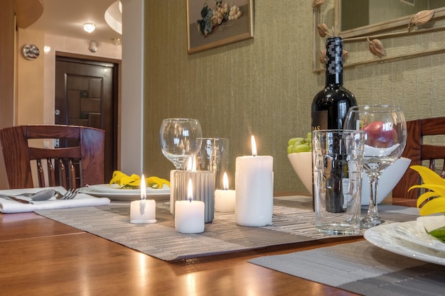 MINSK BELARUS AUGUST 2021 Interior of kitchen in studio apartments with a served table with wine fruit and candles
