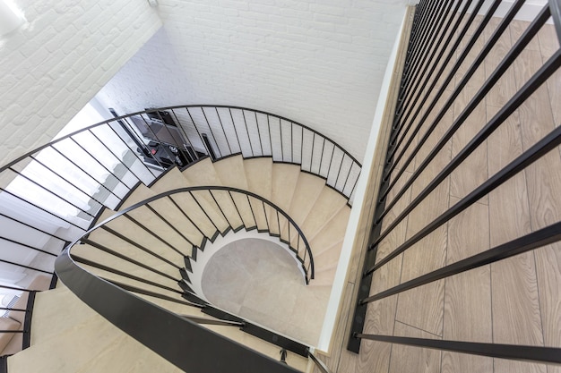 MINSK BELARUS JANUARY 2019 spiral staircase in bright interior with white brick wall in elite expensive apartment