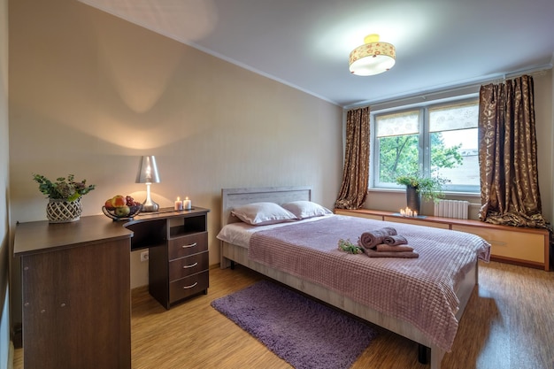 MINSk BELARUS JULY 2021 Interior of the modern luxure bedroom in studio apartments in pink dark color style with candles