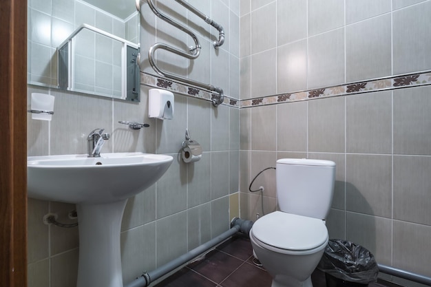 MINSK BELARUS MARCH 2020 water tap sink with faucet in small bathroom detail of a corner shower cabin with wall mount shower attachment in cheap hotel