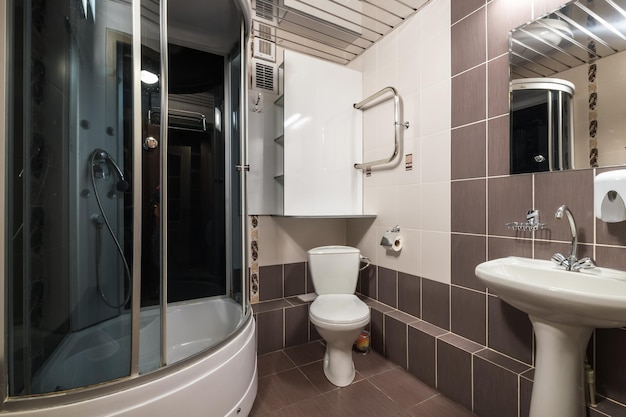 MINSK BELARUS MARCH 2020 water tap sink with faucet in small bathroom detail of a corner shower cabin with wall mount shower attachment in cheap hotel