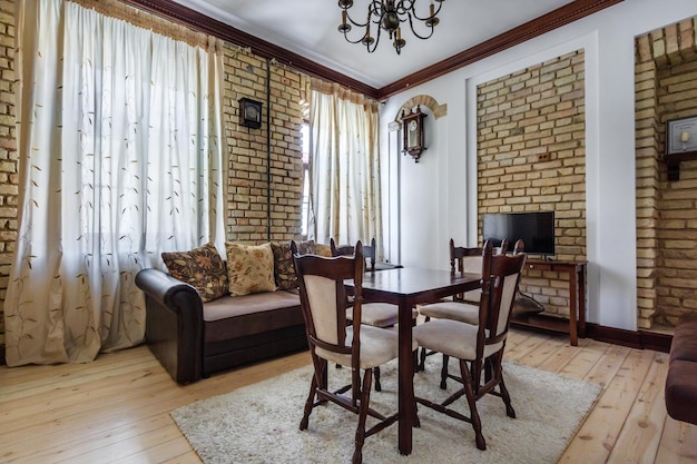 MINSK BELARUS MAY 2020 Interior of vintage biedermeier interior guestroom in studio apartments with sofa table chairs and tv