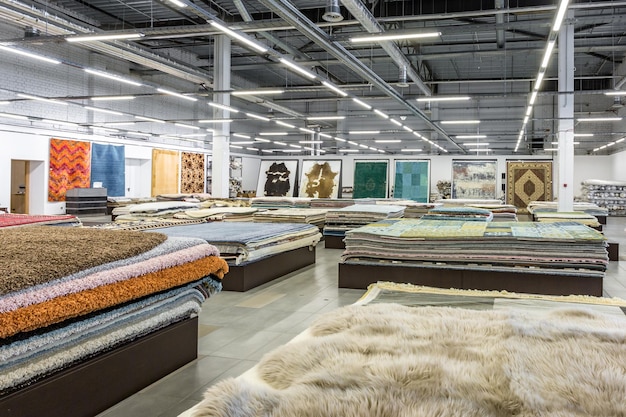 Minsk belarus september 2019 inside interior of elite store of\
machine knitted handmade carpets stacks of carpets