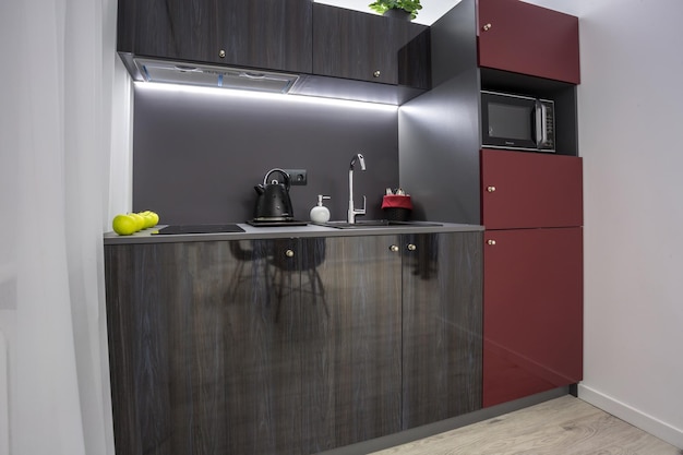 MINSK WIT RUSLAND MAART 2020 Interieur van de moderne luxe keuken met gastentafel in studio-appartementen in minimalistische stijl met donkerrode kleur