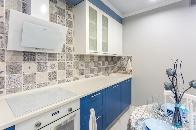 MINSK WIT-RUSLAND SEPTEMBER 2019 Interieur van de moderne luxe keuken met gastentafel in studio-appartementen in minimalistische stijl met blauwe kleur