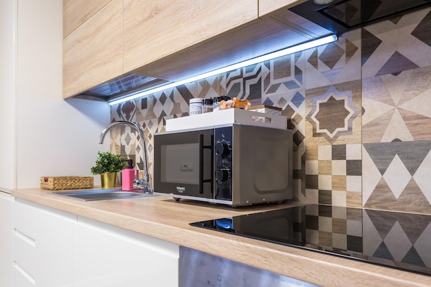 MINSK WIT-RUSLAND SEPTEMBER 2019 Interieur van de moderne luxe keuken met gastentafel in studio-appartementen in minimalistische stijl