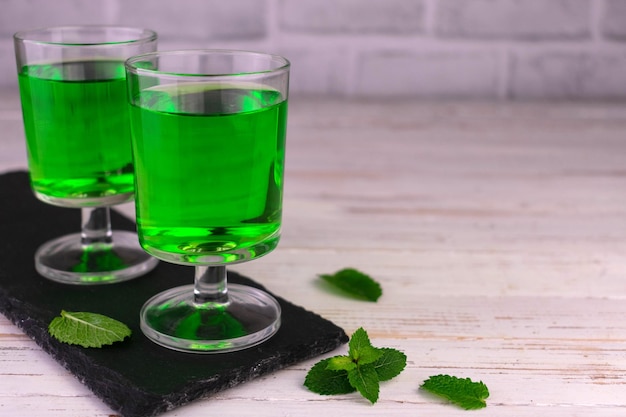 Mint alcoholische drank op een witte houten achtergrond. Kopieer ruimte.