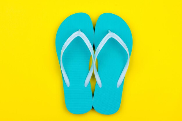 Mint colored swimming slippers on a yellow background