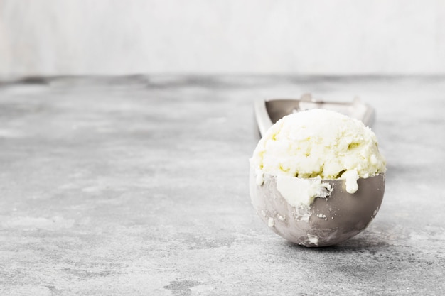 Mint ice cream in spoon on a gray background. 