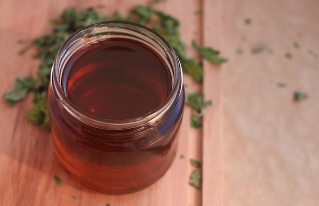 Photo mint leaf syrup in a glass jar with dry mint leaves