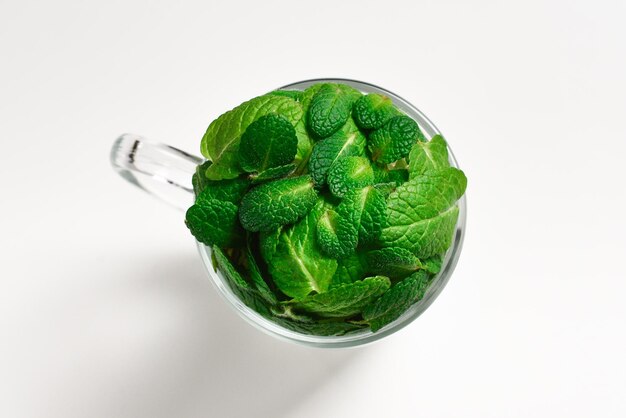 Mint leaves in a cup isolated on white background