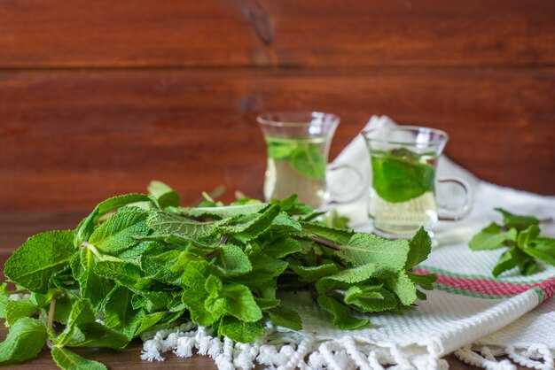 mint liefs met 2 kleine glazen theekopjes op achtergrond op houten tafel