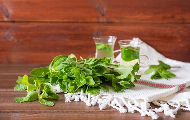 mint liefs met 2 kleine glazen theekopjes op achtergrond op houten tafel