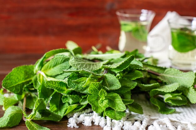 mint liefs with 2 small glass tea cups on background on wooden table