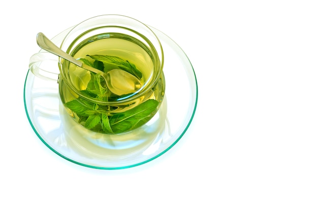 Mint tea in a glass transparent cup on a saucer