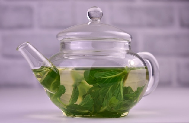 Mint tea in a transparent glass teapotCloseup