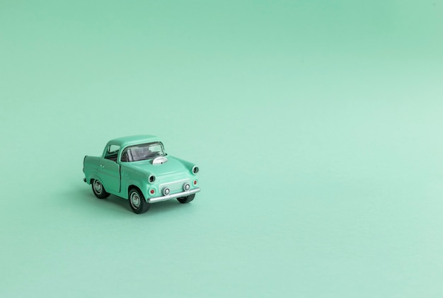 Mint toy car on the road on a neo mint background.