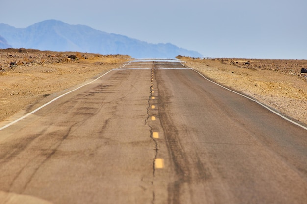 山と砂漠の風景の中の道路で撮影された蜃気楼