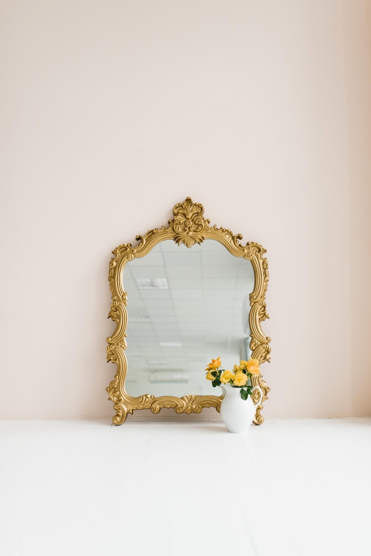 Premium Photo | A mirror in a classic gold frame and potted flowers in
