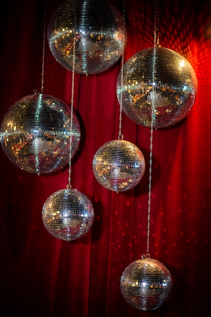 Foto sfere da discoteca a specchio sullo sfondo di una tenda di velluto rosso