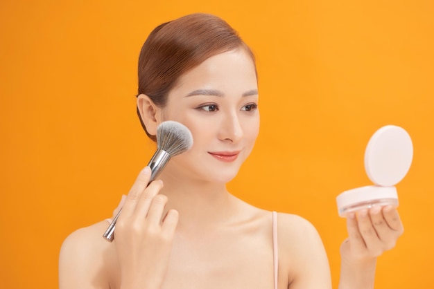 Mirror reflection of beautiful young woman applying makeup