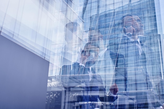 Mirror reflection of a businessman talking on the phone in a glass business building