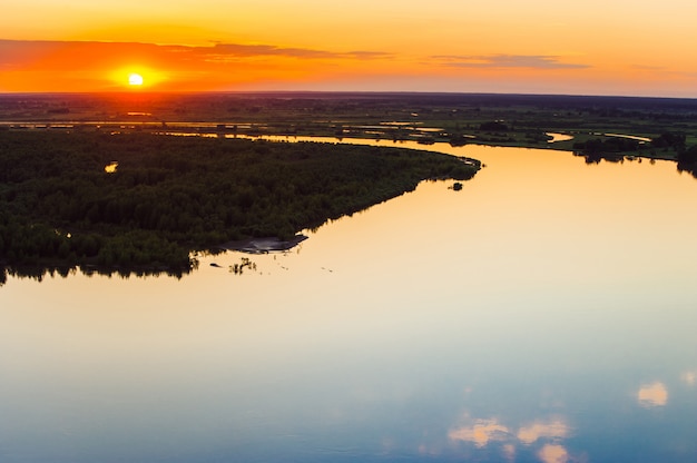 Mirror surface of water at sunset. Altai region. Islands on the river.