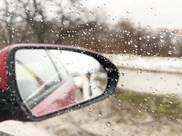 mirror with a car through the window with raindrops