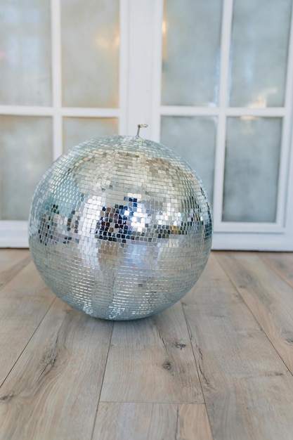 Mirrored disco ball on the floor in the room elements of decor\
in retro style accessories for parties and holidays