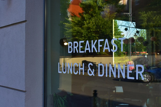 Photo mirrored window with white inscription breakfast lunch and dinner cafe and restaurants