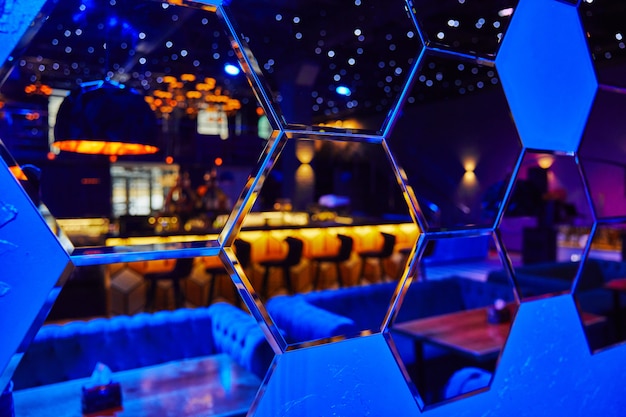 Photo mirrors in the form of many hexagons in which the night club is reflected