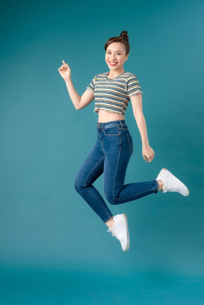 Mischievous girl wearing striped T-shirt and jeans dancing