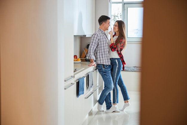 Donna maliziosa che prende in giro il marito in cucina