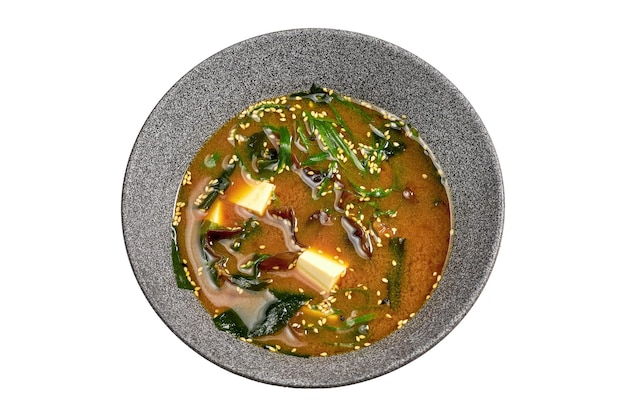 Misosoep met shiitake-tofu en zeewier in een kom op een witte achtergrond