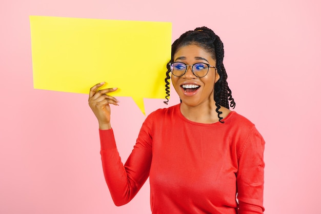 Photo don't miss excited shocked black girl holding empty speech bubble over pink studio wall free space