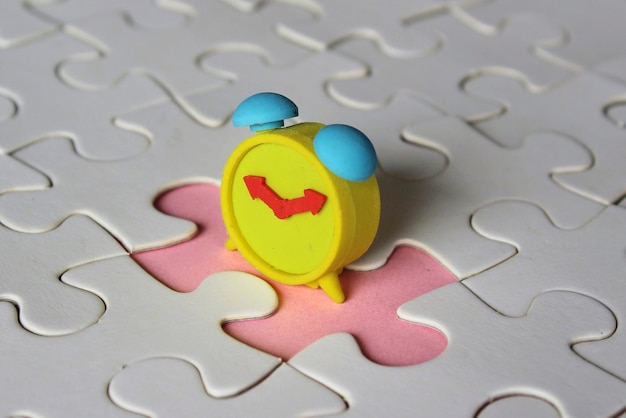 Missing jigsaw puzzle pieces and alarm clock Time management concept