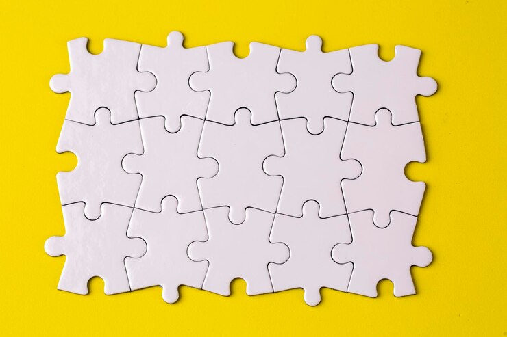 Photo missing jigsaw puzzle pieces business concept fragment of a folded white jigsaw puzzle and a pile of uncombed puzzle elements against