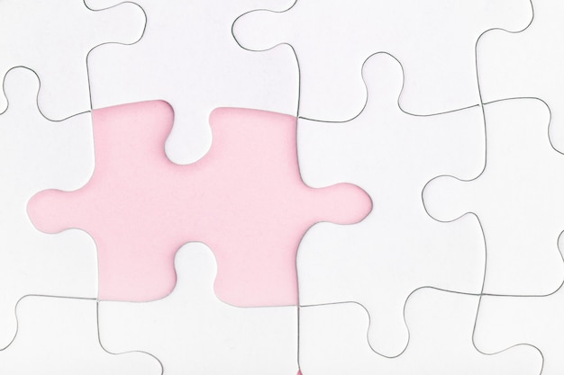 Missing piece of jigsaw puzzle on pink