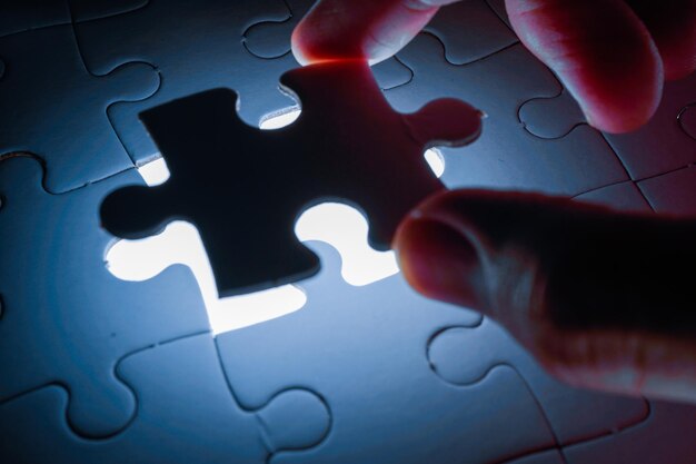 Photo missing piece of jigsaw puzzle with light glow business concept for completing final puzzle piece