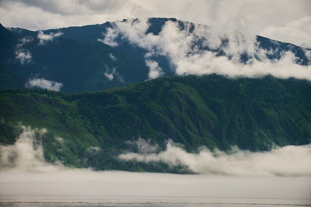 Mist in de ochtendmist van de bergvallei over het meer in het altai-gebergte