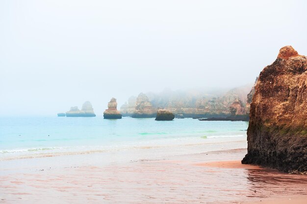 Mistige ochtend aan de kust van de Atlantische Oceaan in de Algarve, Portugal. Beroemde reisbestemming