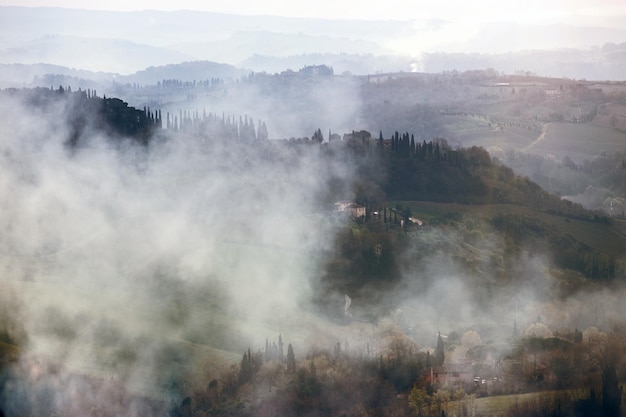 Mistige ochtend op de Toscana met de opkomende zonnestralen