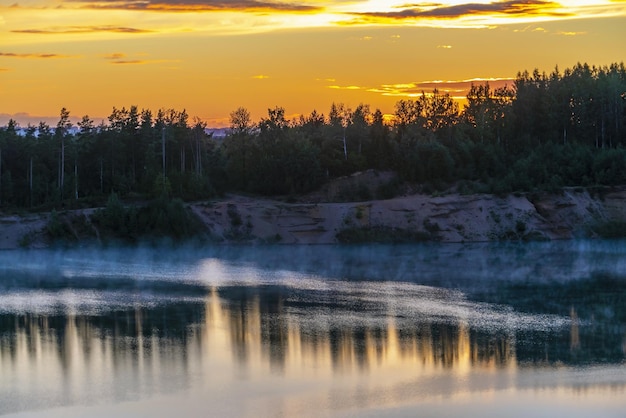 Mistige waas over het water tijdens zonsondergang