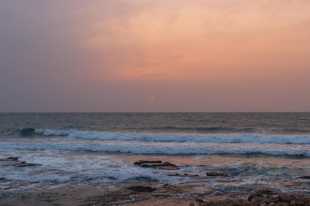 Mistige zonsondergang op het strand bij haifa