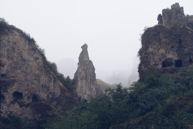 Mistweergave op de oude grotstad Khndzoresk in de bergrotsen Armenië landschapsattractie Verlaten ruïnes in de mist Atmosferisch stock fotografie