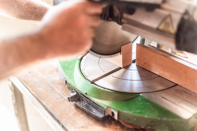 Photo miter saw in motion blurred hand in foreground