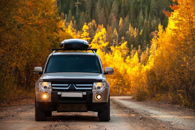 Mitsubishi Pajero op schilderachtige herfstweg in prachtig bos